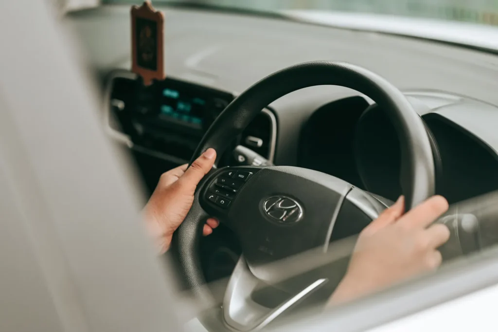 Close-up of a driver holding the steering wheel of a car in motion