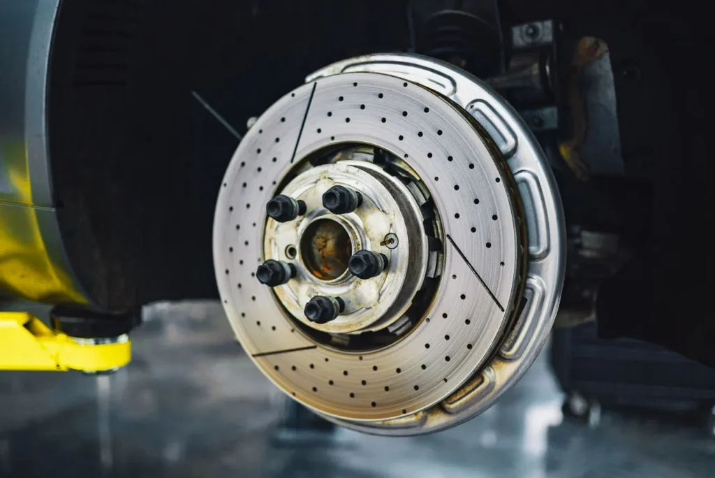 Brake disc and hub exposed on a vehicle raised on a workshop lift
