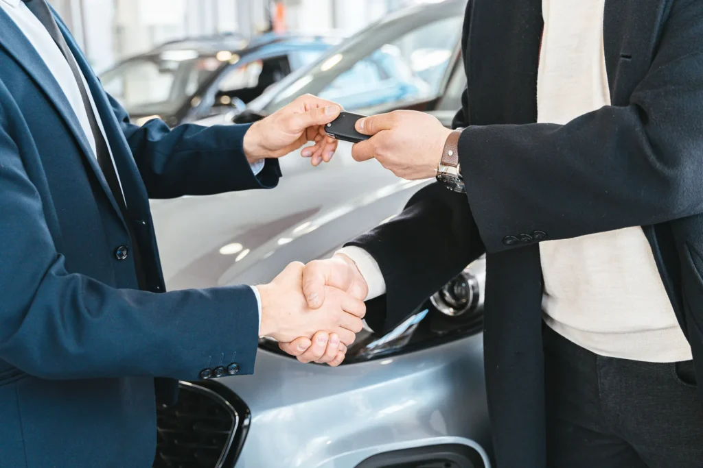 Handshake beside a car as the keys are handed over