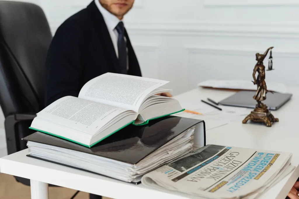 Open law book and scales of justice on an attorney desk